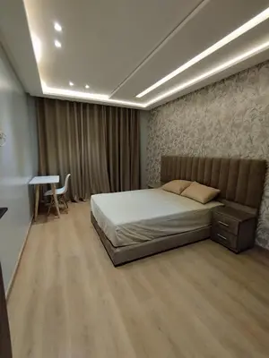 a bedroom with a bed and a table in it at Rosa Luxury Apartment , Confort, Vue Dégagée , Parking Privé près du CFC in Casablanca