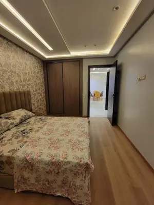 a bedroom with a bed with a floral bedspread at Rosa Luxury Apartment , Confort, Vue Dégagée , Parking Privé près du CFC in Casablanca