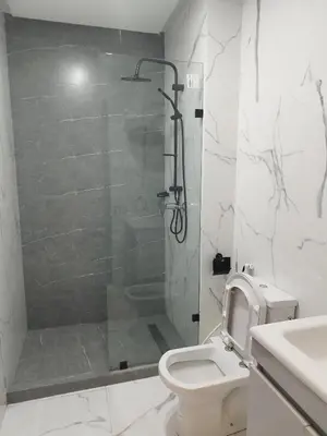 a white bathroom with a shower and a toilet at Rosa Luxury Apartment , Confort, Vue Dégagée , Parking Privé près du CFC in Casablanca