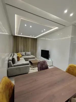 a living room with a table and a couch at Rosa Luxury Apartment , Confort, Vue Dégagée , Parking Privé près du CFC in Casablanca