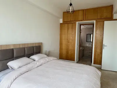 a bedroom with a large bed and a bathroom at Atlantica in Rabat