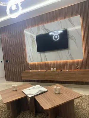 a room with a table and a tv on a wall at Comfortable apartment in a gated community in Casablanca
