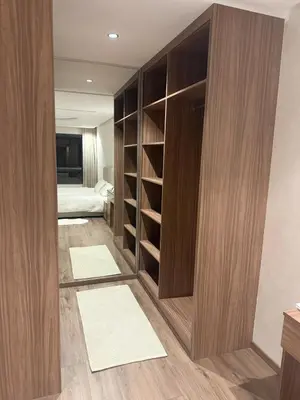 a room with a closet with wooden cabinets and a bed at Comfortable apartment in a gated community in Casablanca