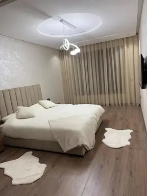 a bedroom with a bed and two rugs on the floor at Comfortable apartment in a gated community in Casablanca