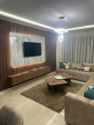 a living room with a couch and a flat screen tv at Comfortable apartment in a gated community in Casablanca