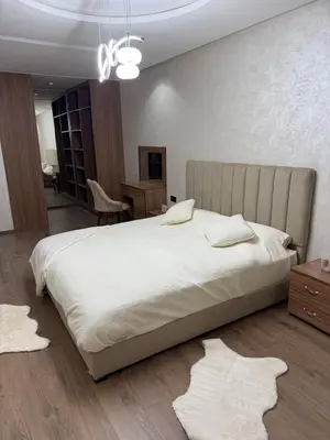 a bedroom with a large white bed and a desk at Comfortable apartment in a gated community in Casablanca