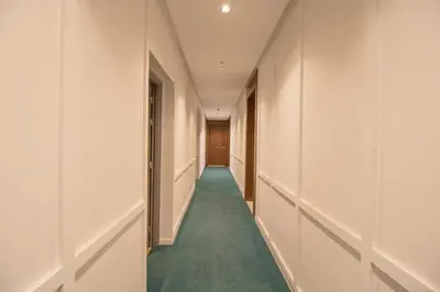 a hallway with white walls and a green carpet at Elegant Studio in Maarif - Gym access & Free Parking & Wifi Fiber in Casablanca