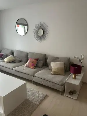 a living room with a gray couch and a mirror at My Cosy Place Luxury 2BR Apartment CasaFinanceCity in Casablanca