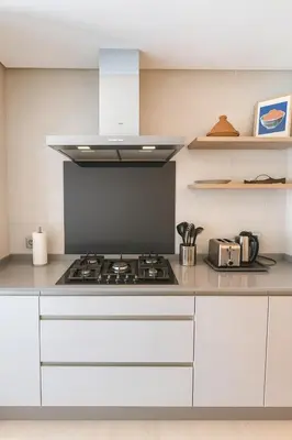 a kitchen with white cabinets and a stove top oven at My Cosy Place Luxury 2BR Apartment CasaFinanceCity in Casablanca