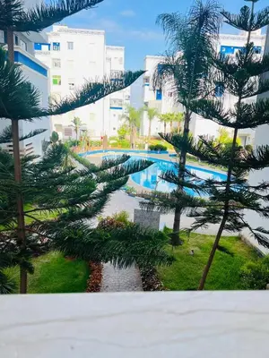 a view of a swimming pool with trees and buildings at Fal azure in Bouznika