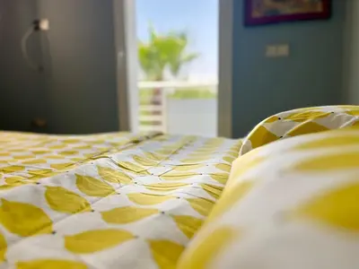 a yellow and white comforter on a bed at Charming villa in a coastal area in Casablanca