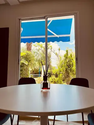 a white table in front of a window with a vase on it at Charming villa in a coastal area in Casablanca
