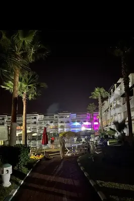 a city at night with palm trees and buildings at Garden beach 2 in Sidi Rahal