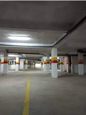 an empty parking garage with white columns and a yellow line at Garden beach 2 in Sidi Rahal