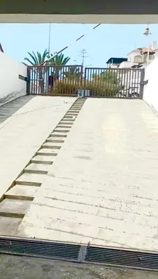 an empty sidewalk with a gate and stairs on it at Garden beach 2 in Sidi Rahal