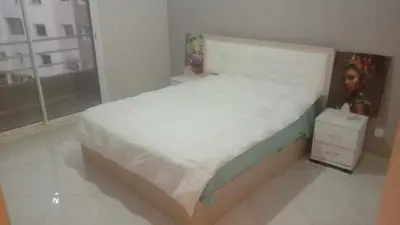 a bedroom with a bed with two dolls on it at Aicha Iliana in Bouznika