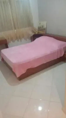 a bedroom with a bed with a pink bedspread at Aicha Iliana in Bouznika