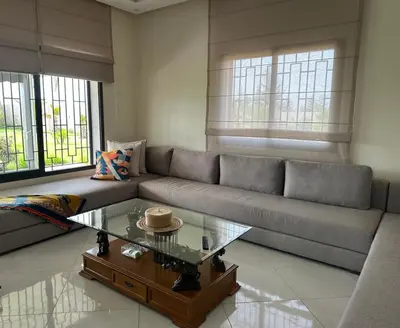 a living room with a couch and a coffee table at la ferme du bonheur in Aïn el Apuda
