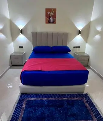 a bedroom with a large bed with a red and blue blanket at Superbe T3 ensoleillé avec Terrasse - 2 chambres - Casablanca in Casablanca