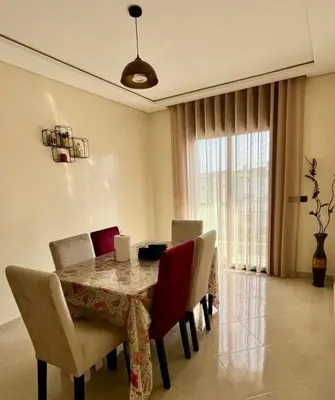 a dining room with a table and chairs and a window at Superbe T3 ensoleillé avec Terrasse - 2 chambres - Casablanca in Casablanca