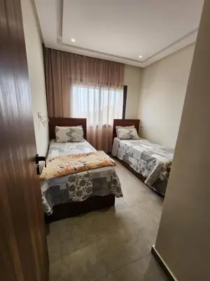 a bedroom with two beds and a window at Apparemment de détente in Mansouria