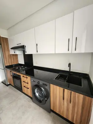 a kitchen with a sink and a washing machine at Apparemment de détente in Mansouria