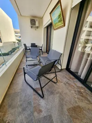 a room with chairs and a table and windows at Apparemment de détente in Mansouria