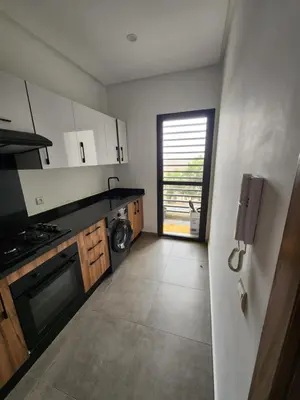 a kitchen with a sink and a stove top oven at Apparemment de détente in Mansouria