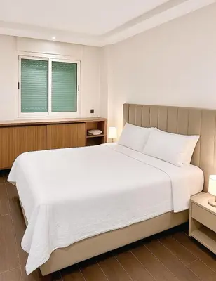 a bedroom with a large white bed and a window at Chic, well-equipped apartment in a perfect location in Temara