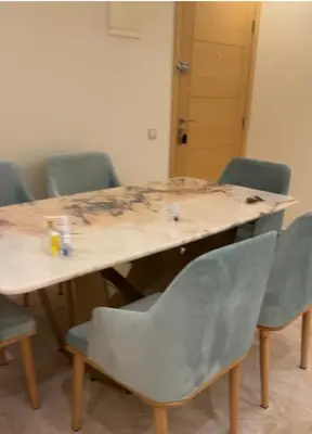 a table with four chairs and a wooden table with at Luxe appartement in Bouznika