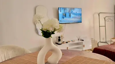 a white vase with white flowers on a table at Charming City Retreat in Agdal - Walk to Train Station in Rabat