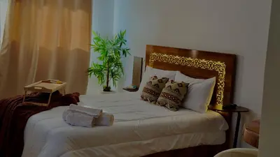 a bedroom with a bed with white sheets and pillows at Charming City Retreat in Agdal - Walk to Train Station in Rabat
