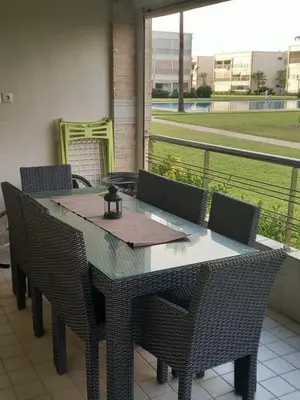 a table and chairs with a view of a field at Résidence balnéaire - Piscine Plage et Diverses in Sidi Rahal