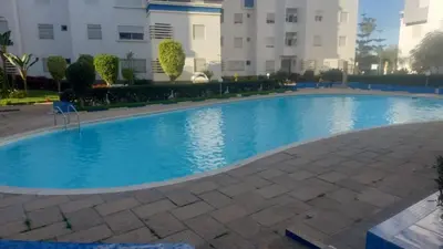 a large blue swimming pool in front of a building at La vie de vacances fal azur in Bouznika