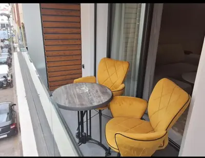 a balcony with yellow chairs and a table on a balcony at Bsmilah in Rabat