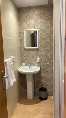 a bathroom with a sink and a tv on the wall at Superbe appartement à l'Agdal in Rabat