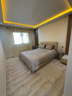 a bedroom with a bed and a window at Appartement à Dahomey - Bouznika in Bouznika