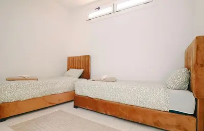 two beds sitting next to each other in a room at Casa Nova Maison moderne à deux pas de la plage in Bouznika