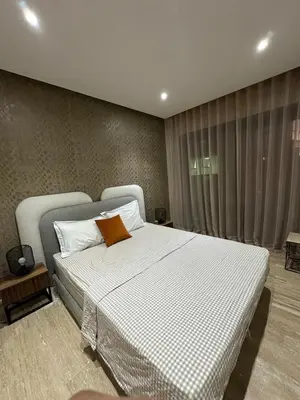 a bedroom with a white bed with a orange pillow at Cosy Family 2BR Apartment - Terrace & Sunset Views in Casablanca