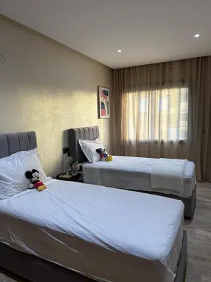 two beds in a hotel room with a teddy bear sitting on them at Cosy Family 2BR Apartment - Terrace & Sunset Views in Casablanca