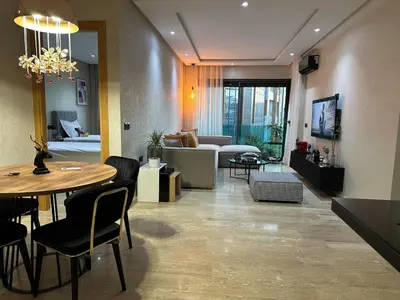 a living room with a table and a couch at Cosy Family 2BR Apartment - Terrace & Sunset Views in Casablanca