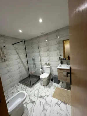 a marble bathroom with a toilet and a sink at Cosy Family 2BR Apartment - Terrace & Sunset Views in Casablanca