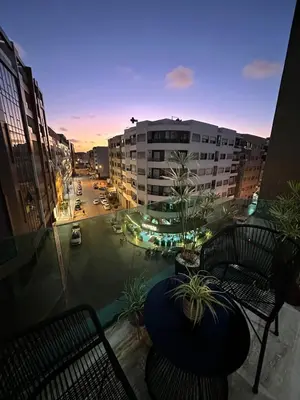 a view of a city at night from a balcony at Cosy Family 2BR Apartment - Terrace & Sunset Views in Casablanca