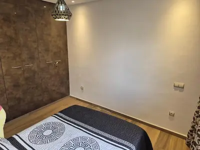 a bedroom with a bed and a shower in a room at Appart pour Famille balnéaire Accés direct à la Mer in Sidi Rahal