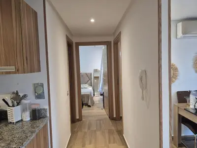 a kitchen with a hallway leading to a bedroom at Appart pour Famille balnéaire Accés direct à la Mer in Sidi Rahal