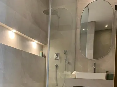 a bathroom with a shower with a sink and a mirror at Villa Moderne et élégante Piscine Golf Resort in Casablanca