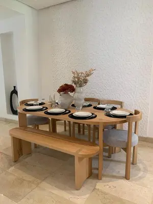 a wooden table with plates and flowers on it at Villa Moderne et élégante Piscine Golf Resort in Casablanca