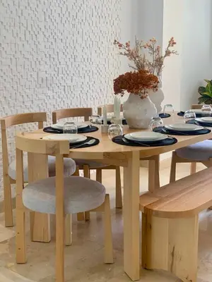 a wooden table with chairs and a vase with flowers at Villa Moderne et élégante Piscine Golf Resort in Casablanca
