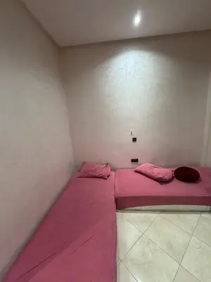 a small room with a pink bed in the corner at 3 bedroom apartment with living room and terrace 90metre in El Harhoura