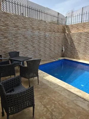 a swimming pool with chairs and a table and a table and a tablektop at Floor Villa rent in El Harhoura